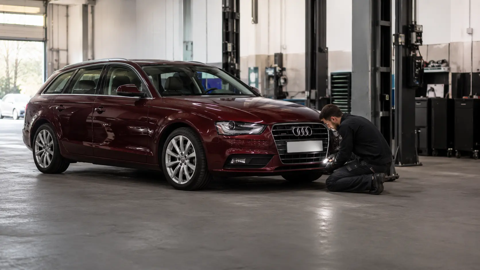 Burgundy Audi A4 Avant being inspected in a Dubai specialist workshop