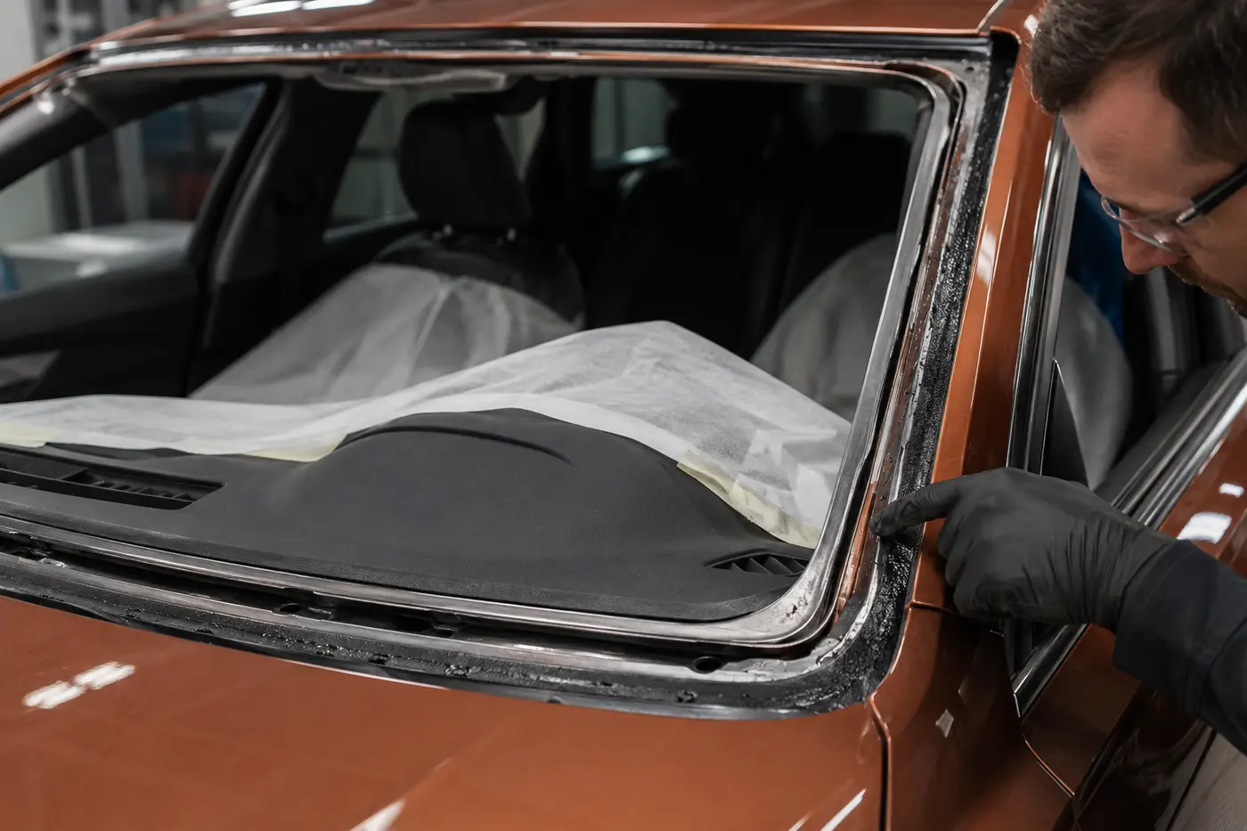 Technician inspecting the windshield bonding aperture after glass removal